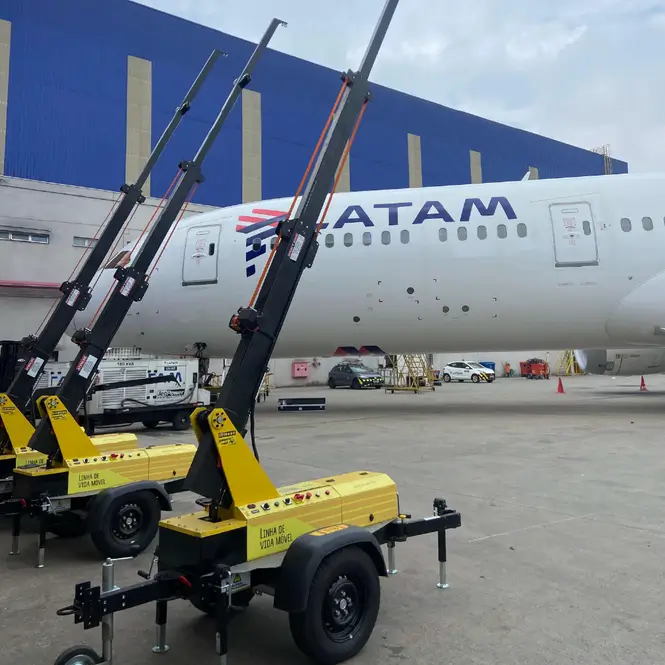 Unidades AMX em hangar de aeroporto com avião LATAM ao fundo, demonstrando versatilidade.